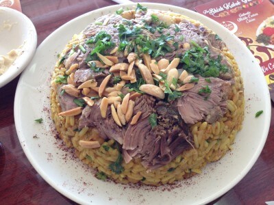 Stuffed Lamb on rice with browned almond slices and parsley