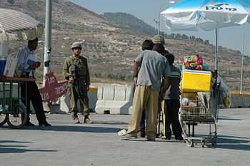 An Israeli soldier buys from Palestinian child...