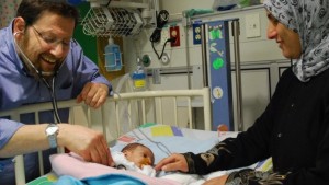 Prof. Azaria JJT Rein, head of pediatric cardiology at Hadassah and cofounder of A Heart for Peace, tending to a Palestinian patient. Photo courtesy A Heart for Peace (PRNewsFoto/Untold News)