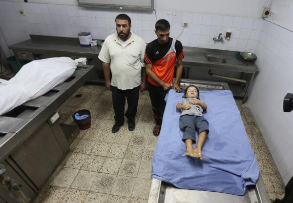 The body of 4 year old Rahaf Hassan is prepared for burial in a Gaza Mortuary. Rahaf was murdered along with her mother, and her mother's unborn baby by an Israeli military terrorist airstrike against civilian targets in Zeitoun, Gaza Strip early Sunday morning, Oct. 11, 2015. Copyright (C) 2015 Mohammed Asad. All Rights Reserved.