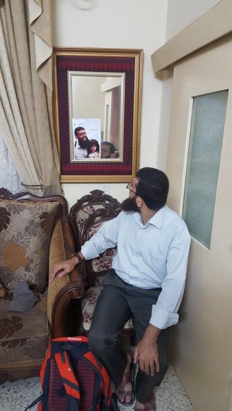 Khader Adnan looks in a mirror at himself at his home