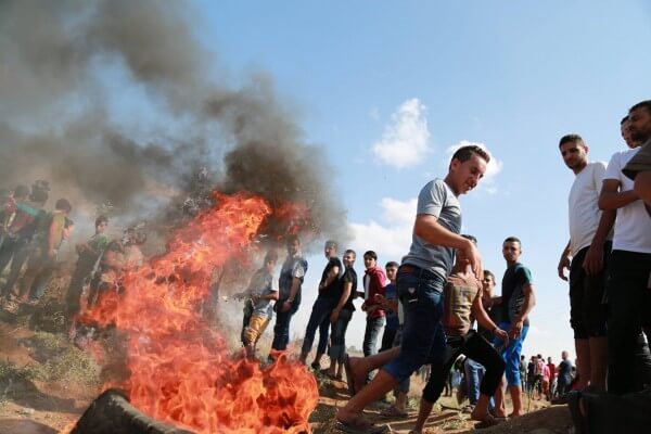 Palestinians in the Gaza Strip near Shujaiya throw stones back at Israeli soldiers who fire live weapons from the border. Copyright (C) Tarek Masood 2015. All Rights Reserved