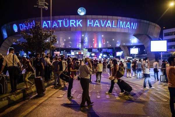 EDITORS NOTE: Graphic content / People stand outside the entrance as they leave the airport after two explosions followed by gunfire hit the Turkey's biggest airport of Ataturk in Istanbul, on June 28, 2016.  At least 10 people were killed on June 28, 2016 evening in a suicide attack at the international terminal of Istanbul's Ataturk airport, Turkish Justice Minister Bekir Bozdag said. Turkey has been hit by a string of deadly attacks in the past year, blamed on both Kurdish rebels and the Islamic State jihadist group. / AFP / OZAN KOSE        (Photo credit should read OZAN KOSE/AFP/Getty Images)