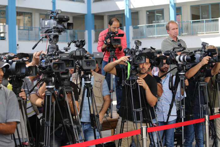 News media, reporters, microphones, Journalists at the UN School in Beit Lahi, Gaza Strip wait for the press briefing by António Guterres, the ninth Secretary-General of the United Nations. Guterres visited Palestine August 29 and 30, 2017. Photo courtesy of Mohammed Asad.