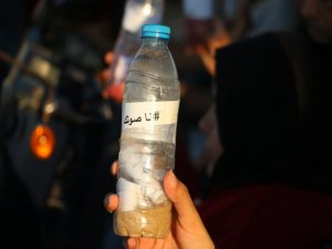Palestinian athletes send messages of hope in plastic bottles in sea during marathon for the disabled. Photo copyright Ahmad Hasaballah. All Rights reserved.