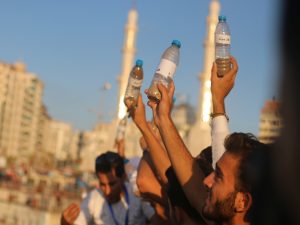 Palestinian athletes send messages of hope in plastic bottles in sea during marathon for the disabled. Photo copyright Ahmad Hasaballah. All Rights reserved.