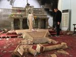 A priest examines the ruins, including a decapitated statue of Mary, in the Catholic church in Karamdes, Iraq, following the town's liberation from ISIS. (PRNewsfoto/Knights of Columbus)
